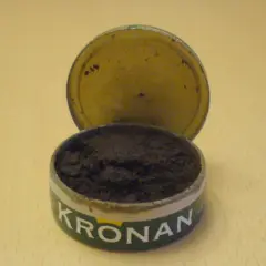En öppen snusdosa med snus. Kronan-loggan syns tydligt. En klassisk snusdosa storlek.