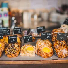 Frestelser på ett café. Vackra bullar och wienerbröd med prislappar, redo att avnjutas med en kopp kaffe.