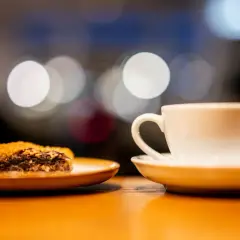 En vit kaffekopp och en bit chokladkaka på ett fat. Perfekt för en fika, en synonym för njutning.