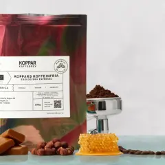 En påse med "Koppars Kaffeinfria Ekologiska Espresso" bredvid choklad, hasselnötter och honungskaka. Perfekt för en liten espresso.
