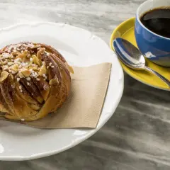 En kanelbulle med pärlsocker och mandelspån, perfekt till en kopp svensk kaffe.
