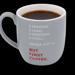 Grå mugg med texten "BUT FIRST COFFEE." och en text som antyder 50mg koffein. Perfekt för morgonrutinen.