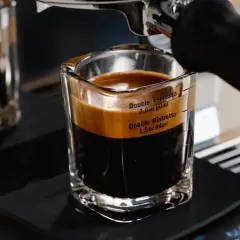 A double ristretto and double espresso in a glass shot with measurement markings.