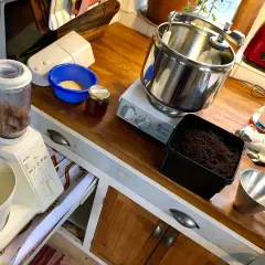 Förbereder för att mala tobak till snus. Köksbänk med mixer, skål med tobak, burk med honung och en köksmaskin.