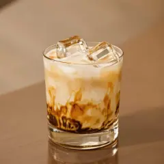 En glas med freddo cappuccino, is och mjölk som virvlar i en vacker marmorering. Perfekt för en varm sommardag.