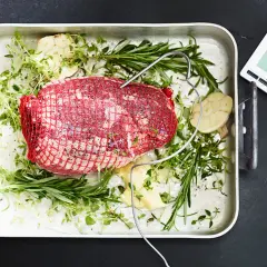 Råstek med örter och vitlök i ugnsform, redo att koka te. En digital termometer visar 10°C.