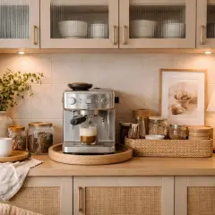 En mysig kaffebar hemma med espressomaskin som brygger en cappuccino. Kaffebönor i glasburkar och en vit kopp på en träbricka.
