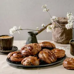 En kopp kaffe och kanelbullar, en klassisk kombination för fika i Sverige. Våren är här med blommande körsbärsgrenar.