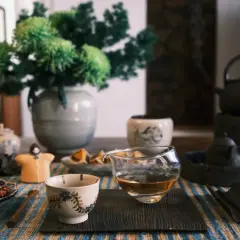 En vacker teceremoni med en skål med granatäppelkärnor, en liten figur och en karaff med gyllene te. Perfekt svart te temperatur.