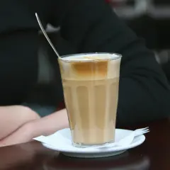 En person njuter av en kaffe latte, en av många olika typer av kaffe.