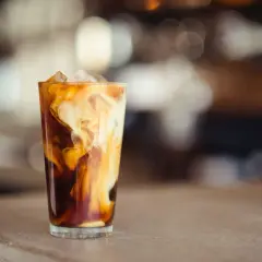 Glas med isbitar och virvlande grädde i mörkt kaffe, en härlig alkoholfri irish coffee.