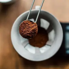 Malen kaffe hälls i en filterhållare. Rätt kaffe temperatur är avgörande för en god brygd.
