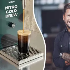 En leende man med tatueringar på armen bredvid en maskin som gör nitro cold brew.
