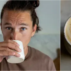 Man med blå ögon dricker en vacker latte hemma. Kaffet har ett hjärtformat mönster i skummet.