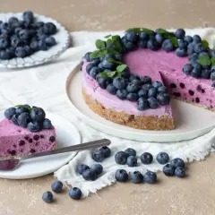 En härlig blåbärstårta, perfekt för fredagsfika på jobbet. En bit är upplagd på en tallrik med en gaffel.