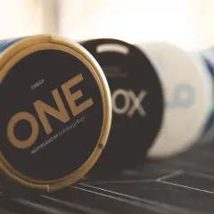 En dosa ONE, inspirerad av Göteborgs Rapé, en av sveriges mest sålda snus. Flera dosor i bakgrunden.