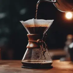 Vatten hälls över kaffepulver i en Chemex. En vacker pour over-process som skapar en rik och aromatisk kopp kaffe.