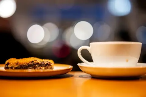 En vit kaffekopp och en bit chokladkaka på ett fat. Perfekt för en fika, en synonym för njutning.