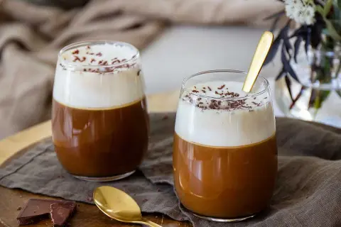 Två glas med en lyxig kaffedrink, toppad med grädde och choklad. Kanske en kaffedrink med Kahlúa och Cointreau?