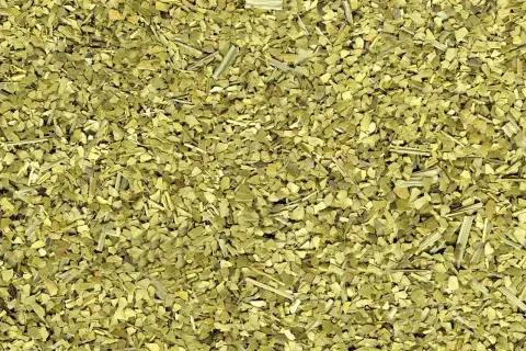Torkade blad och stjälkar av yerba mate, en grön, krispig blandning redo att bryggas.