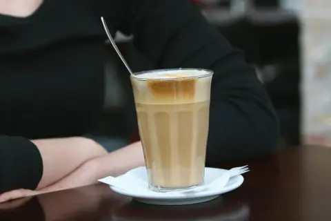 En person njuter av en kaffe latte, en av många olika typer av kaffe.