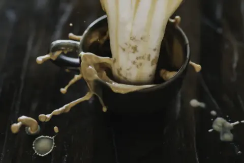 Kaffe skvätter ur en kopp, en bild som kan associeras med inflammation i kroppen.