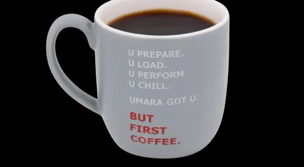 Grå mugg med texten "BUT FIRST COFFEE." och en text som antyder 50mg koffein. Perfekt för morgonrutinen.