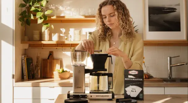 Kvinna förbereder sig för att brygga kaffe utan filter med en Moccamaster.