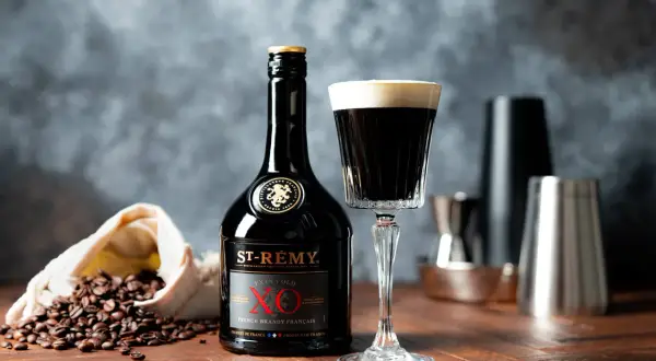 En elegant drink med kaffe och konjak, bredvid en flaska St-Rémy XO och kaffebönor.