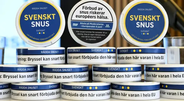 Stackar av vita snusdosor med texten "SVENSKT SNUS" och uppmaningar att rädda snuset.