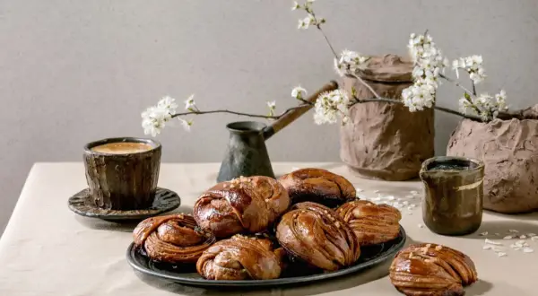En kopp kaffe och kanelbullar, en klassisk kombination för fika i Sverige. Våren är här med blommande körsbärsgrenar.