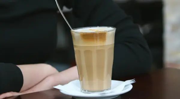 En person njuter av en kaffe latte, en av många olika typer av kaffe.