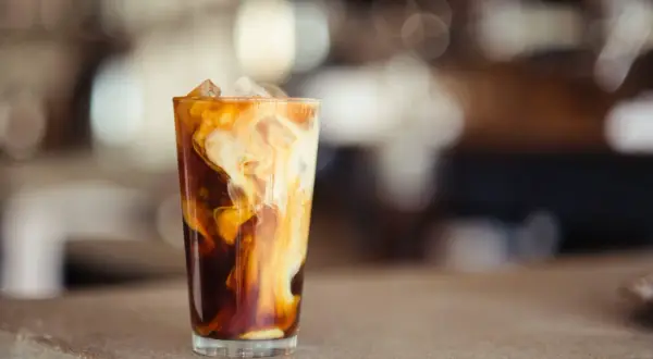 Glas med isbitar och virvlande grädde i mörkt kaffe, en härlig alkoholfri irish coffee.