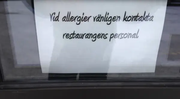 En lapp på ett fönster uppmanar: "Vid allergier vänligen kontakta restaurangens personal." Perfekt för den som är allergisk mot kaffe och vill vara säker.