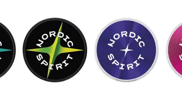 Fyra runda logotyper med texten "NORDIC SPIRIT" och en stjärna. En med svart bakgrund och turkos stjärna, en med svart bakgrund och grön/gul stjärna, en med lila bakgrund och en lila stjärna, samt en med rosa bakgrund och en rosa stjärna.