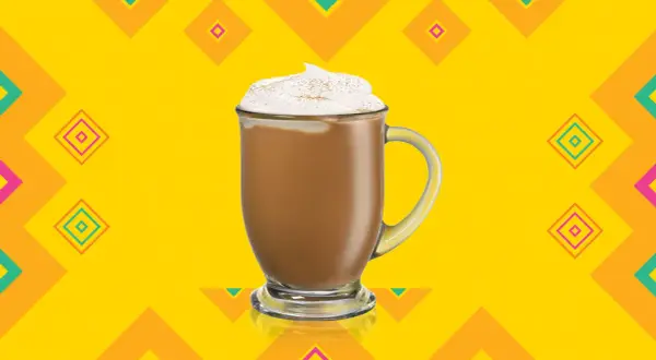 En krämig kaffedrink med kahlua, toppad med vispgrädde och kanel, mot en färgglad bakgrund.
