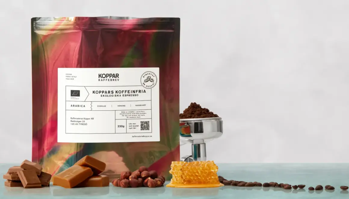 En påse med "Koppars Kaffeinfria Ekologiska Espresso" bredvid choklad, hasselnötter och honungskaka. Perfekt för en liten espresso.