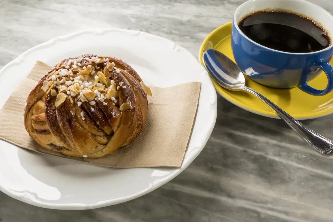 En kanelbulle med pärlsocker och mandelspån, perfekt till en kopp svensk kaffe.