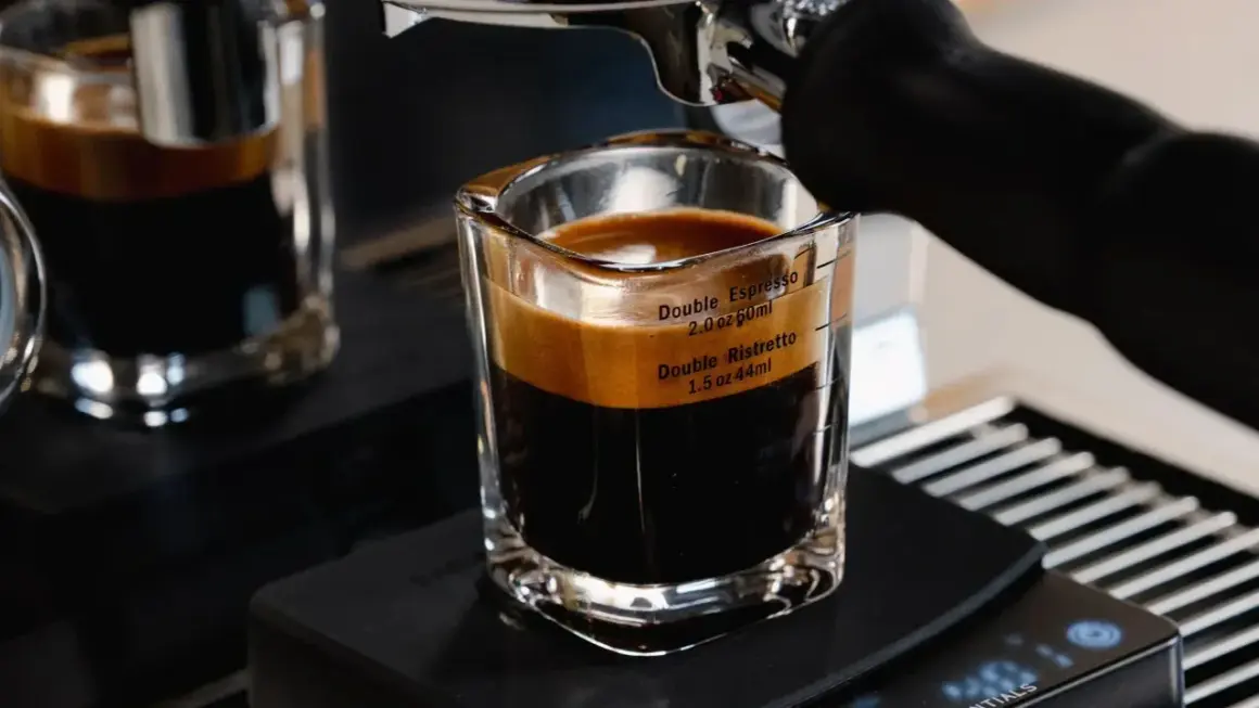 A double ristretto and double espresso in a glass shot with measurement markings.