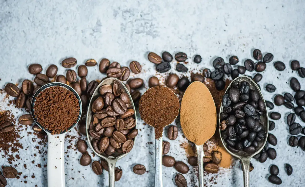 Fem skedar visar olika stadier av kaffe produktion: från hela bönor till fint malet pulver.