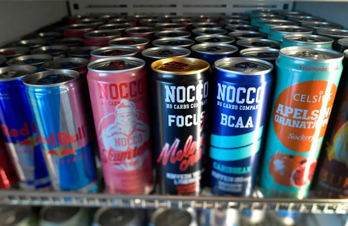 En rad NOCCO-burkar, inklusive "Skumtomte" och "Focus Melon Crush", samt Red Bull och Celsius. Frågan "hur mycket koffein i NOCCO" kan besvaras genom att läsa på burkarna.