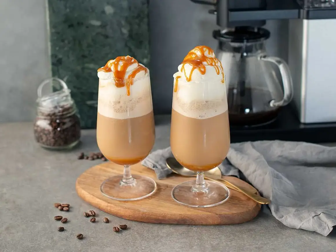 Två glas med krämig frappe caramel, toppade med vispgrädde och karamellsås. Perfekt för en fika.