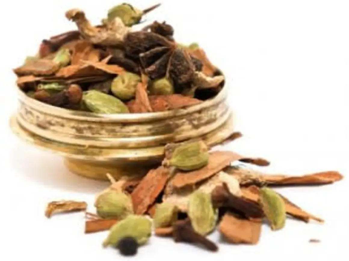 En gyllene skål fylld med en aromatisk chai kryddblandning: kanel, kardemumma, stjärnanis och nejlikor.