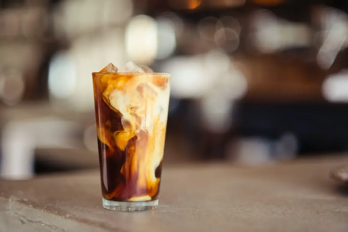 Glas med isbitar och virvlande grädde i mörkt kaffe, en härlig alkoholfri irish coffee.