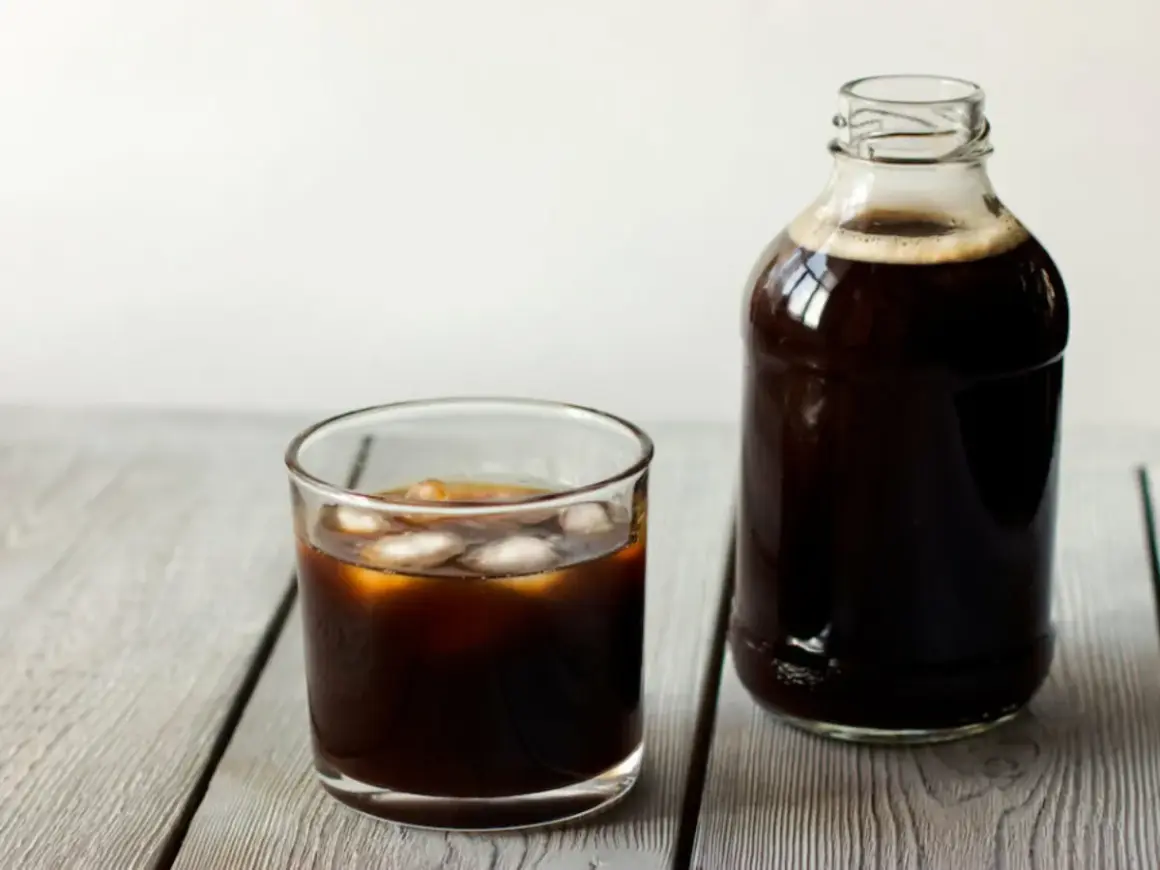 Ett glas islat kaffe bredvid en flaska med kallbryggt kaffe. Perfekt för ett enkelt cold brew recept.