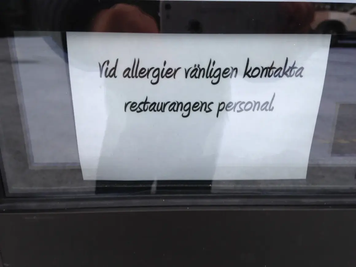 En lapp på ett fönster uppmanar: "Vid allergier vänligen kontakta restaurangens personal." Perfekt för den som är allergisk mot kaffe och vill vara säker.