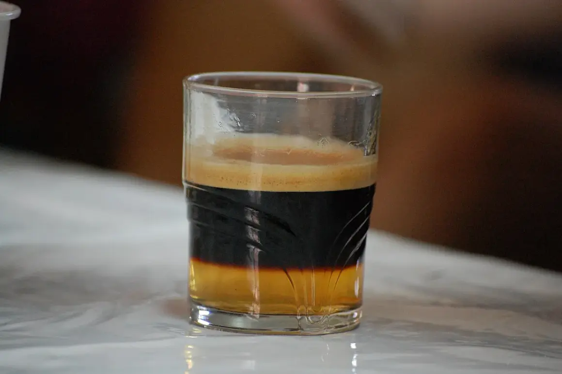 En spansk kaffedrink med lager av kaffe och skum i ett glas.