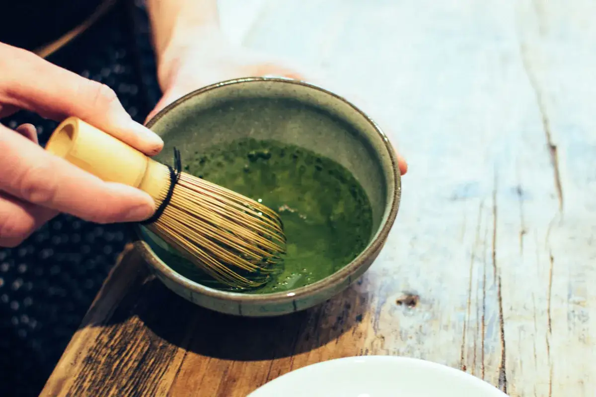 En hand vispar intensivt gr&ouml;n matcha i en sk&aring;l. Snart f&aring;r vi veta vad smakar matcha.