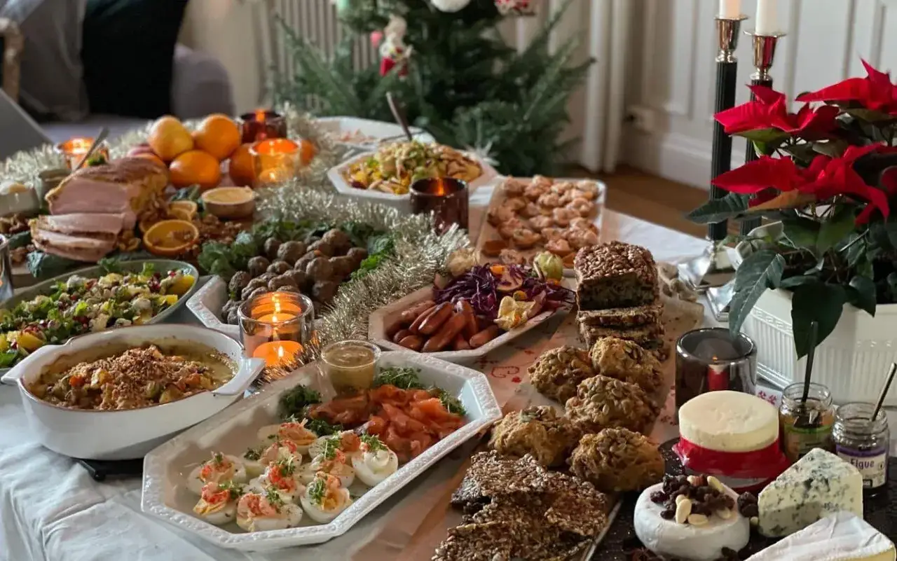 Ett dignande bord med julmat, julgran och julstjärnor. Perfekt för en härlig julfika till många.
