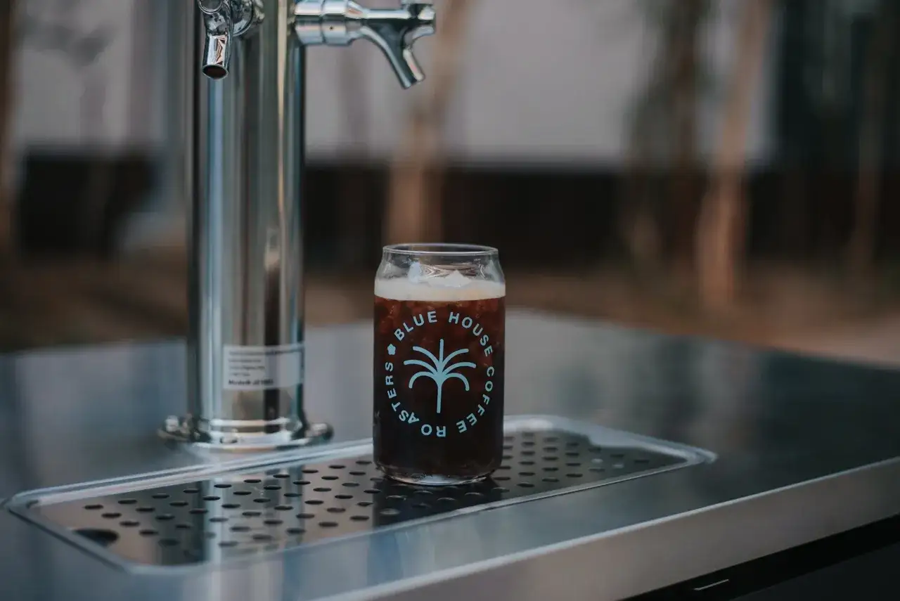 Ett glas med nitro cold brew kaffe står bredvid en tappkran.